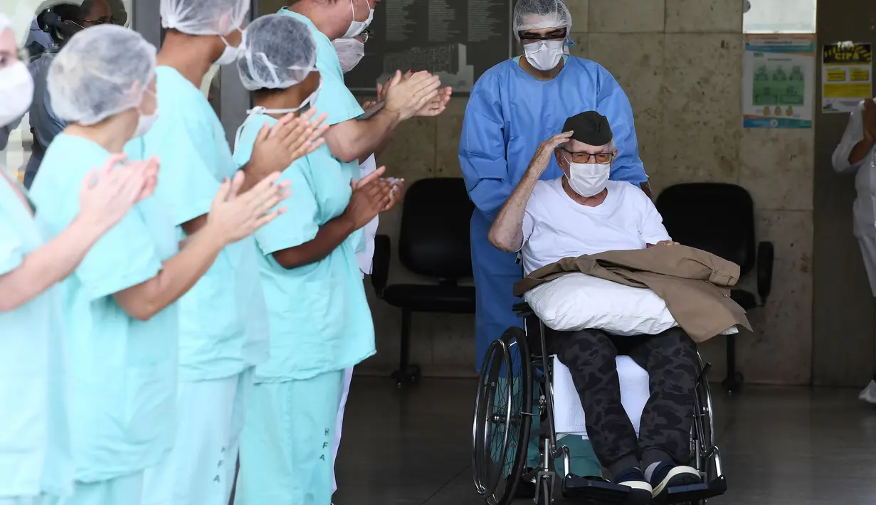 Veteran Perang Dunia II asal Brasil, Ermando Armelino Piveta meninggalkan Rumah Sakit Angkatan Bersenjata setelah pulih dari covid-19 di Brasilia, Selasa (14/4/2020). Kakek berusia 99 tahun itu dinyatakan sembuh dari virus Corona setelah dirawat selama delapan hari. (EVARISTO SA/AFP)
