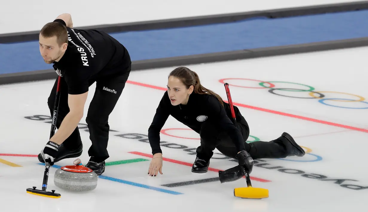 Atlet Curling dari Rusia Anastasia Bryzgalova berlaga bersama rekan setimnya Aleksandr Krushelnitckii dalam Olimpiade Musim Dingin 2018 di Gangneung, Korea Selatan (12/2). (AP Photo / Natacha Pisarenko)