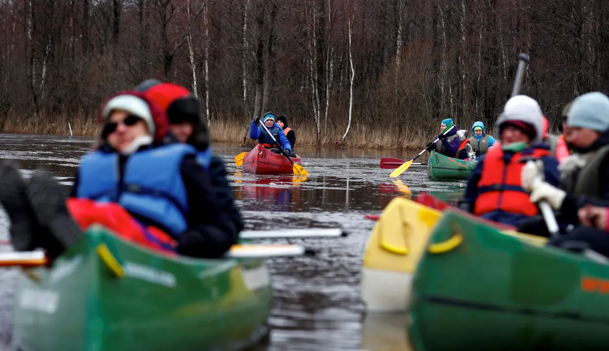 Pengunjung mendayung kayak di tengah banjir yang merendam padang rumput Taman Nasional Soomaa, Estonia, Minggu (17/3). Wisata banjir ini, menjadi daya tarik tersendiri bagi pengunjung. (Reuters/Ints Kalnins)