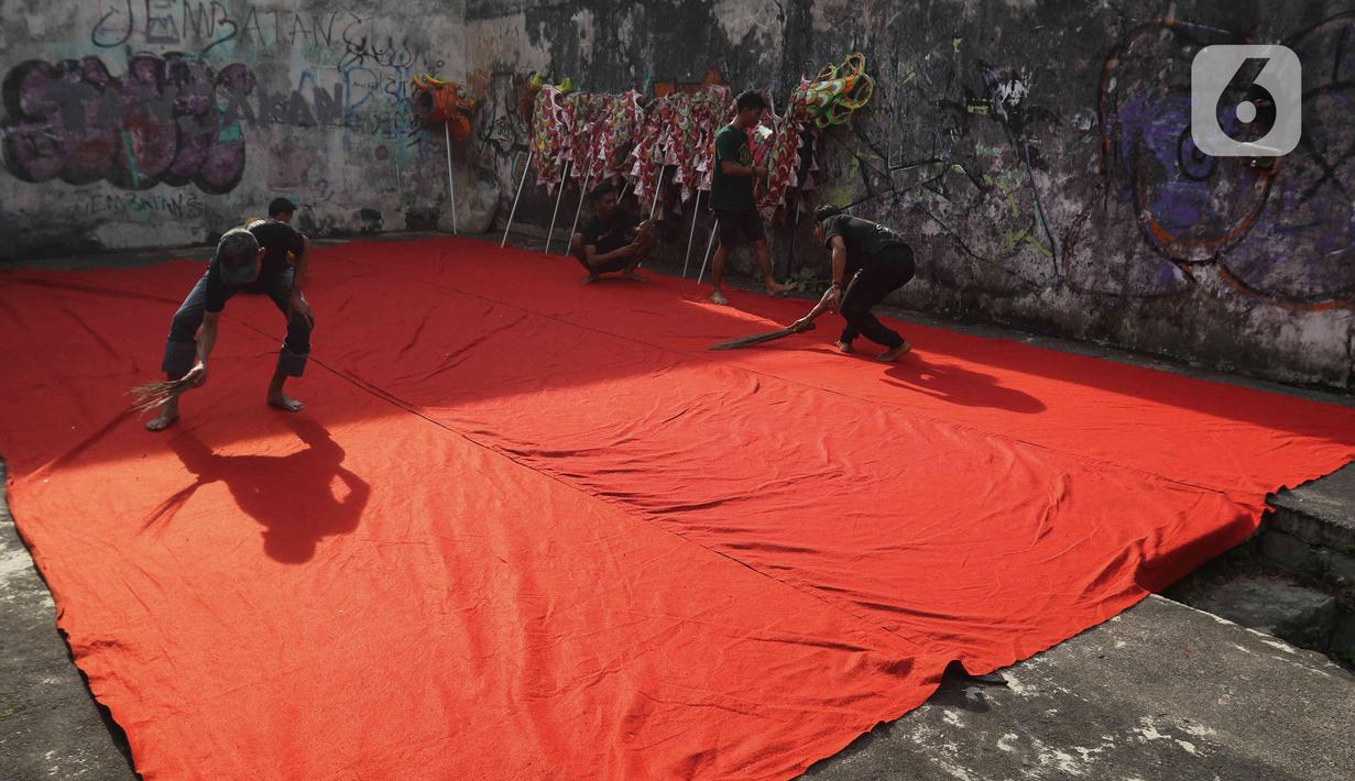 Pemain dari kelompok barongsai Naga Merah Putih Bogor bersiap melakukan latihan dengan Barongsai di kawasan Babakan Pasar, Kota Bogor, Jawa Barat, Rabu (11/1/2023). Latihan tersebut  untuk mempersiapkan penampilan menyambut Tahun Baru Imlek. (Liputan6.com/Herman Zakharia)