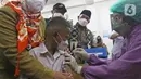 Menko PMK Muhadjir Effendy melihat petugas kesehatan menyuntikkan vaksin COVID-19 kepada siswa di SDN 01 Depok, Depok, Jawa Barat, Selasa (14/12/2021). Kunjungan tersebut untuk melihat persiapan vaksinasi COVID-19 anak usia 6-11 tahun yang dilaksanakan mulai hari ini. (Liputan6.com/Herman Zakharia)
