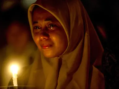 Umat muslim meneteskan air mata ketika mengikuti doa bersama lintas agama saat peringatan setahun tragedi bom gereja Surabaya di luar Gereja Katolik Santa Maria Tak Bercela, Senin (13/5/2019). Pada peringatan itu digelar juga doa lintas agama yang dihadiri sejumlah pemuka agama. (Juni Kriswanto/AFP)