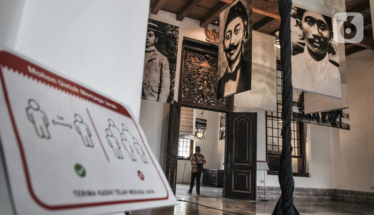 Pengunjung mengamati koleksi foto arsip tentang sejarah Indonesia dalam pameran Indonesia Bergerak 1900-1942 (Revamped) di Gedung Arsip Nasional, Jakarta, Selasa (15/12/2020). Pameran tersebut berlangsung mulai 11 hingga 16 Desember 2020. (merdeka.com/Iqbal Nugroho)