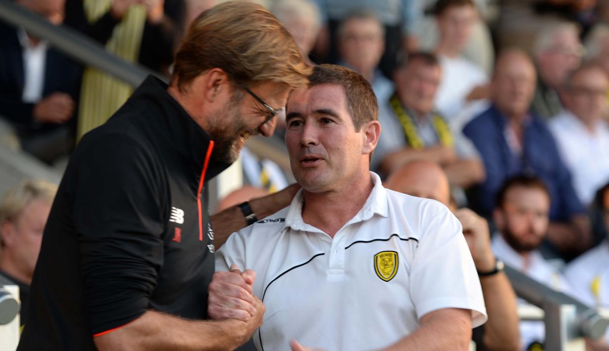 Pelatih Liverpool, Jurgen Klopp (kiri) bersalaman dengan pelatih Burton Albion, Nigel Clough pada putaran kedua piala Liga Inggris di Pirelli Stadium, Burton-on-Trent, (24/8/2016) dini hari WIB.  (AFP/Oli Scarf)