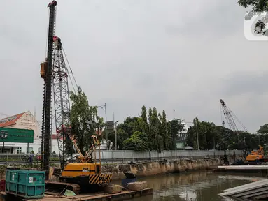 Pekerja menyelesaikan pemasangan dinding turap di kali pasar baru, Jakarta, Rabu (9/3/2022). Dinas Sumber Daya Air DKI Jakarta melakukan pemasangan turap bertujuan untuk mengantisipasi banjir serta tanah ambles di pinggir sungai. (Liputan6.com/Faizal Fanani)