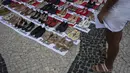 Di sepanjang Pantai Copacabana, pengunjuk rasa memasang 722 pasang sepatu perempuan, mulai dari sepatu hak tinggi hingga sepatu kets. (Tercio TEIXEIRA / AFP)