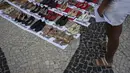 Di sepanjang Pantai Copacabana, pengunjuk rasa memasang 722 pasang sepatu perempuan, mulai dari sepatu hak tinggi hingga sepatu kets. (Tercio TEIXEIRA / AFP)