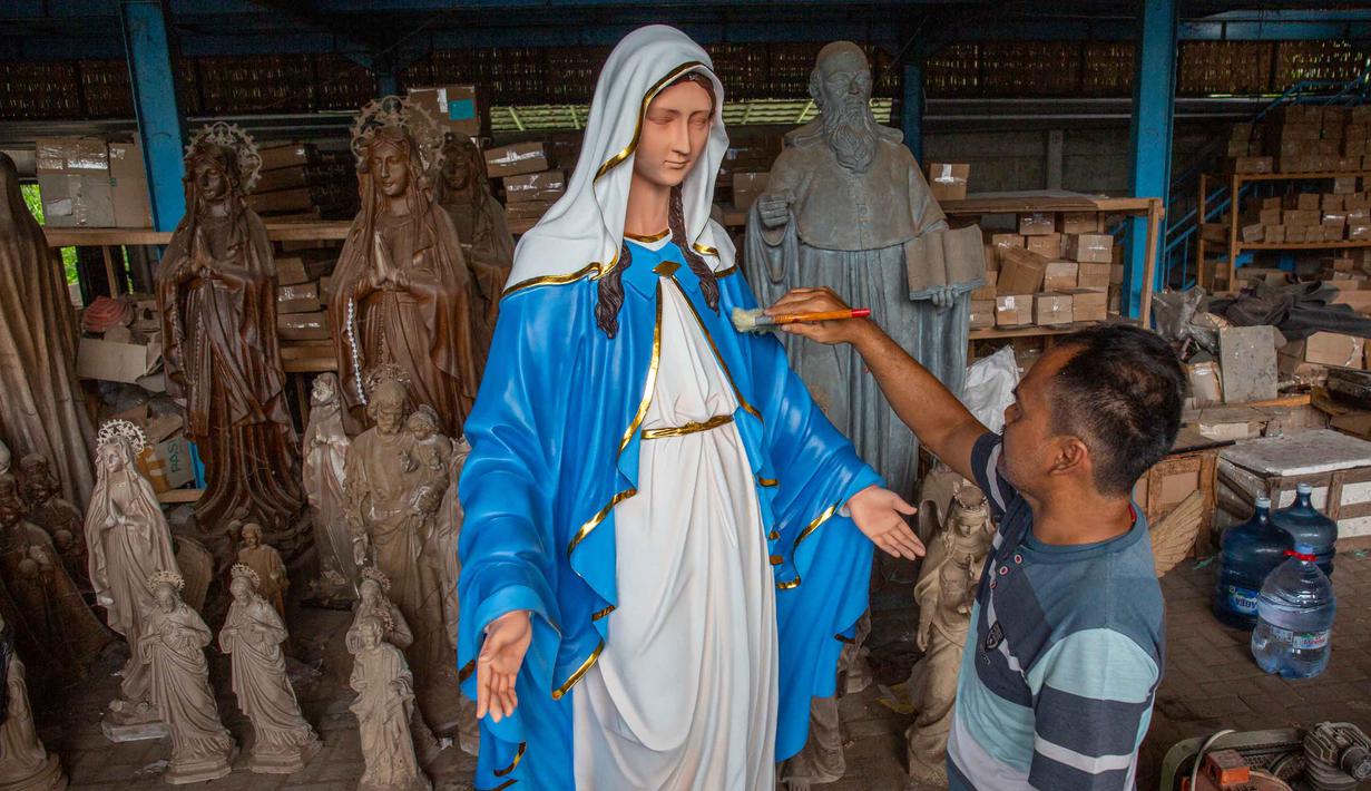 Momen perayaan Natal menjadi berkah bagi perajin di Kabupaten Bantul, Yogyakarta. Tampak dalam foto, seorang pekerja membersihkan patung keagamaan Kristen di bengkel kerajinan Studio Malta Jaya di Bantul, Yogyakarta, pada Kamis 18 Desember 2025. (DEVI RAHMAN/AFP)