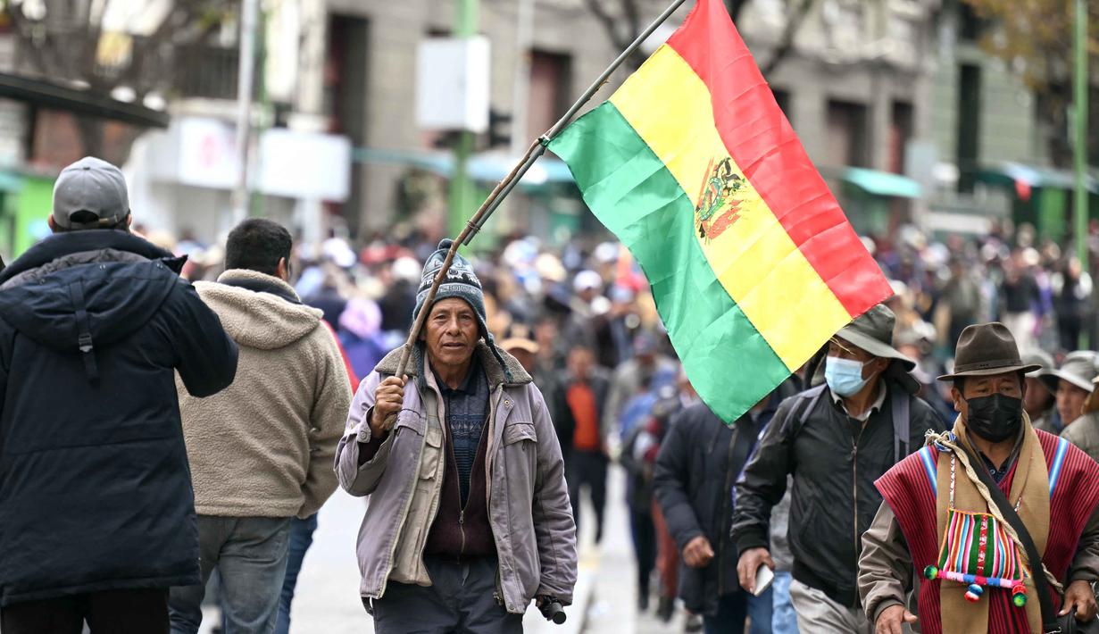 Seorang pria memegang bendera Bolivia selama demonstrasi menentang Presiden Rodrigo Paz di La Paz pada 25 Mei 2026. (Marvin RECINOS/AFP)
