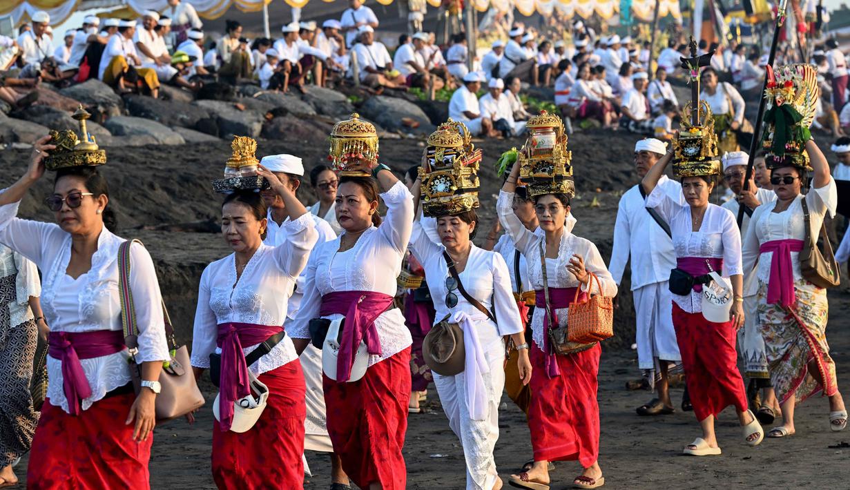 Upacara Melasti dinilai mampu membimbing umat Hindu dalam menjaga hubungannya dengan aspek Tri Hita Karana, yang artinya menjalin hubungan harmonis dengan Tuhan, sesama manusia, dan alam. Tampak dalam foto, umat Hindu saat mengikuti upacara doa Melasti di salah satu pantai di Denpasar, Bali, pada Senin 16 Maret 2026. (SONNY TUMBELAKA/AFP)