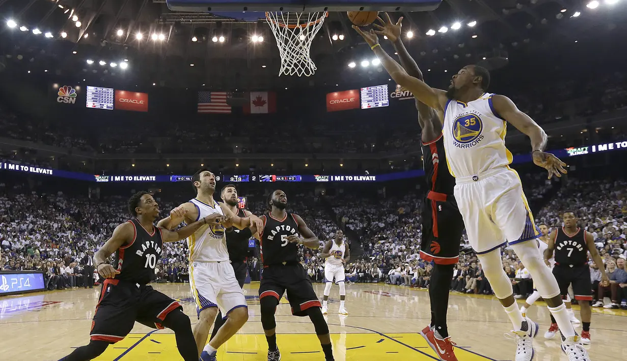 Pemain Golden State Warriors, Kevin Durant #35 melakukan tembakan saat dihadang pemain Toronto Raptors pada lanjutan NBA basketball game di Oracle Arena, (28/12/2016). Warriors menang 121-111. (AP/Jeff Chiu)