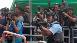 Sejumlah awak media saat meliput simulasi serangan anti-teror di Hong Kong, Jumat, (25/8). Simulasi serangan anti-teror ini untuk persiapan sebuah konser penyanyi Ariana Grande pada 21 September 2017. (AP Photo / Vincent Yu)