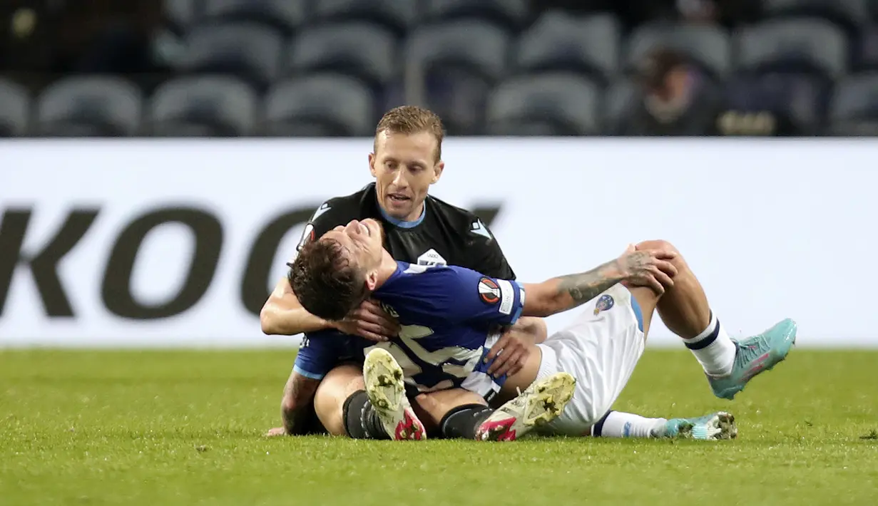 Pemain Lazio Lucas Leiva memegang pemain Porto Otavio setelah tabrakan antara keduanya pada pertandingan Liga Europa di Stadion Dragao, Porto, Portugal, 17 Februari 2022. Porto menang 2-1. (AP Photo/Luis Vieira)