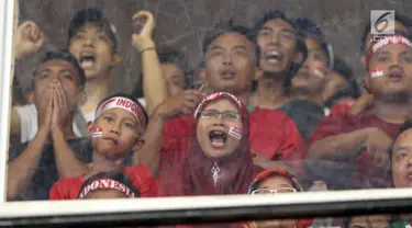 Suportermeluapkan ekspresi saat menyaksikan laga Timnas Indonesia U-19 melawan Jepang U-19 pada perempat final Piala AFC U-19 2018 di Stadion GBK, Jakarta, Minggu (28/10). Indonesia kalah 0-2.