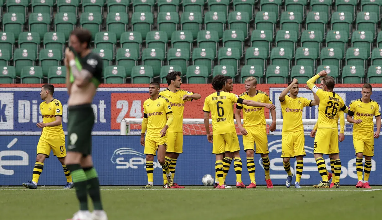 Pemain Borussia Dortmund merayakan gol yang dicetak oleh Raphael Guerreiro ke gawang Wolfsburg pada laga Bundesliga, Minggu (24/5/2020). Borussia Dortmund menang 2-0 atas Wolfsburg. (AP/Michael Sohn)