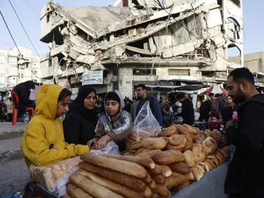 Warga Palestina menjual roti di dekat bangunan yang hancur di pasar Zawiya, Kota Gaza, pada Rabu 18 Februari 2026. Menyambut bulan suci Ramadan 1447 Hijriah, warga Palestina di Kota Gaza memadati Pasar Al-Zawiya. (Omar AL-QATTAA/AFP)