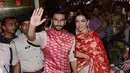 Pasangan pengantin baru, Ranveer Singh dan Deepika Padukone menyapa penggemar yang menyambut mereka di bandara internasional Mumbai, Minggu (18/11). Pasangan bintang Bollywood India itu baru saja kembali dari acara pernikahan mereka di Italia. (AFP)