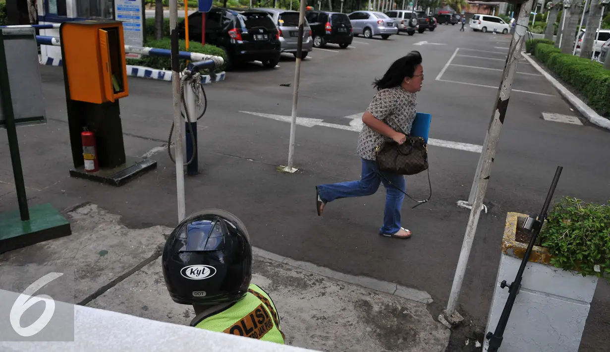  Pekerja berlari saat dievakuasi dari kantor mereka di Thamrin di Jakarta (14/1/2015). Beberapa ledakan dan suara senjata api terjadi di pusat ibukota Indonesia, Polisi mencurigai seorang melakukan aksi bom bunuh diri. (Liputan6.com/Gempur M Surya)