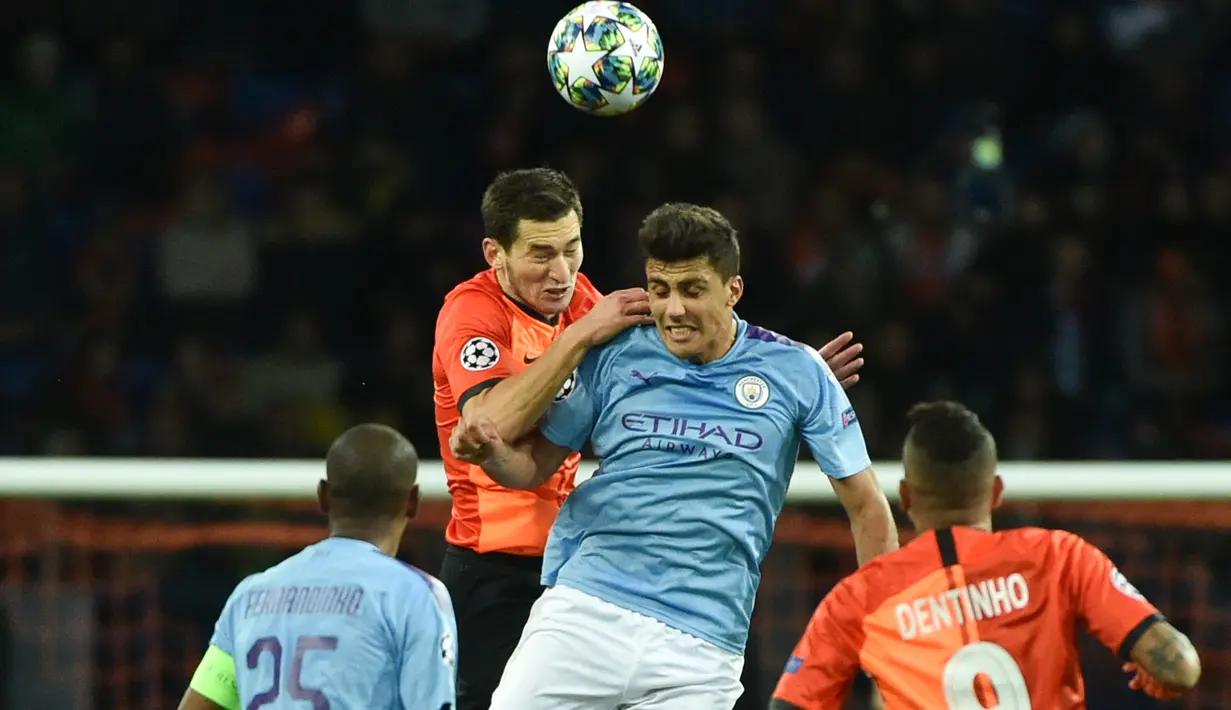 Pemain Shakhtar Donetsk, Taras Stepanenko dan pemain tengah Manchester City, Rodri melompat bersama saat berebut bola pada laga pertama Grup C Liga Champions di Metalist Stadium, Rabu (18/9/2019). Manchester City sukses menghantam Shakhtar Donetsk dengan skor 3-0. (Genya SAVILOV / AFP)