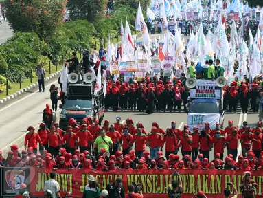 Massa buruh dan pekerja dari berbagai daerah mulai memadati Jalan MH Thamrin, Jakarta, dalam peringatan May Day, Senin (1/5). Mereka mengibarkan bendera organisasi buruh dan membentangkan spanduk di sepanjang perjalanan. (Liputan6.com/Johan Tallo)