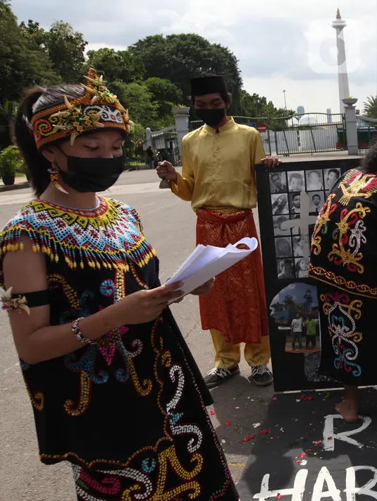 Demonstran melakukan aksi teatrikal saat unjuk rasa di kawasan Bundaran Patung Kuda Arjuna Wijaya, Jakarta, Senin (21/6/2021). Aksi yang dilakukan bertepatan dengan ulang tahun Presiden Joko Widodo ini sebagai bentuk kecaman dan penolakan terhadap revisi UU Minerba. (Liputan6.com/Angga Yuniar)