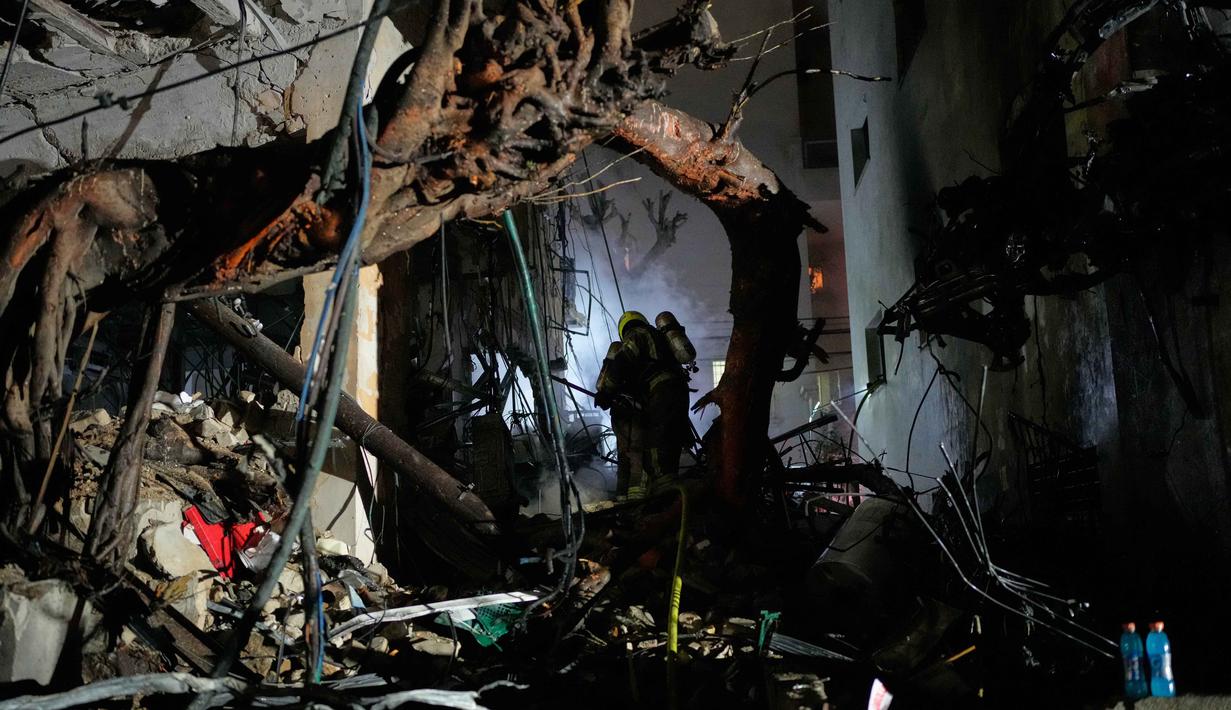 Meski berhasil mencegat sejumlah rudal Iran, namun beberapa dilaporkan berhasil menembus pertahanan dan menghantam infrastruktur di Tel Aviv serta menyebabkan kebakaran di wilayah Galilea. Tampak dalam foto, para petugas dari Komando Pertahanan Dalam Negeri Israel menggeledah reruntuhan gedung apartemen yang rusak akibat serangan rudal Iran di Tel Aviv, Israel, Minggu 1 Maret 2026 dini hari waktu setempat. (AP Photo/Ohad Zwigenberg)