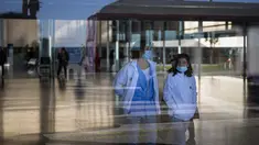 Orang-orang yang memakai masker sebagai tindakan pencegahan berjalan di dalam rumah sakit di Barcelona, ​​Spanyol, Senin (8/1/2024). (AP Photo/Emilio Morenatti)