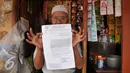 Warga menunjukan surat peringatan ke 3 di Kawasan Bukit Duri, Jakarta, Selasa (20/9). Pemkot Jaksel akan menertibkan bangunan dan permukiman di kawasan Bukit Duri yang berbatasan langsung dengan Sungai Ciliwung. (Liputan6.com/Gempur M Surya)
