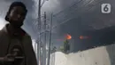 Asap hitam membumbung dari atas Gudang JNE Express yang terbakar di Jalan Pekapuran Raya, Depok, pada Senin (12/9/2022). JNE menjamin barang milik konsumen yang rusak  dalam peristiwa kebakaran gudang di Depok akan diganti. (Liputan6.com/Herman Zakharia)