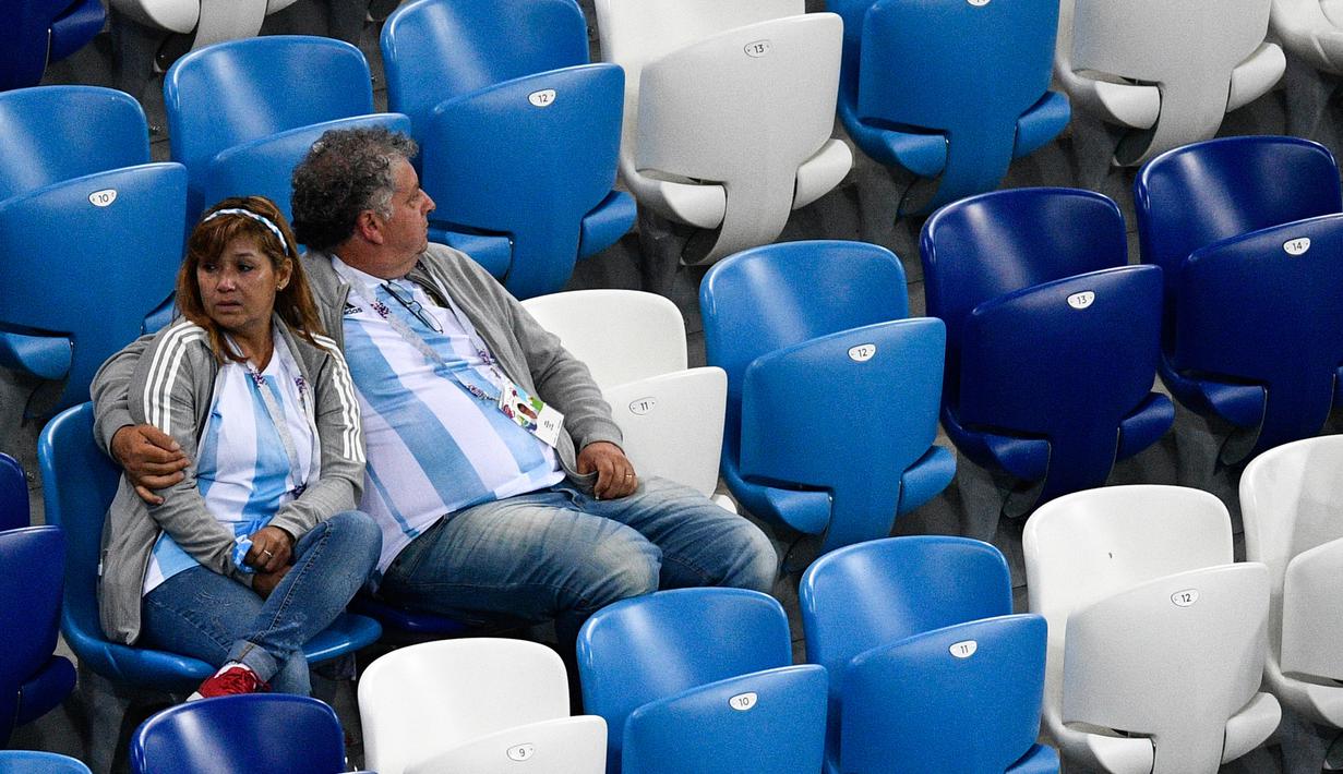 Sepasang suporter Argentina tampak kecewa usai negaranya dikalahkan Kroasia pada laga grup D Piala Dunia di Stadion Nizhny Novgorod, Novgorod, Kamis (21/6/2018). Cerita sepenggal kisah romantis saat Piala Dunia 2018 Rusia. (AFP/Martin Bernetti)