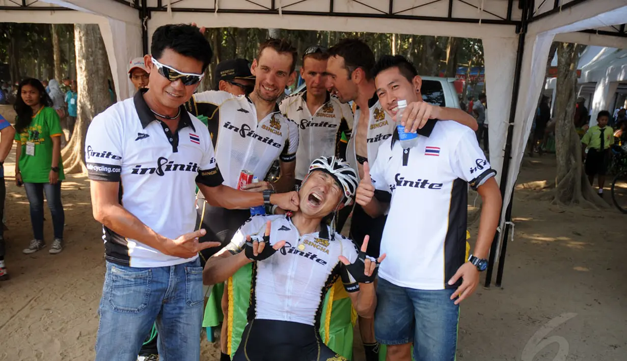 Kyosuke Takei (depan-duduk) meluapkan kegembiraannya bersama timnya, Singha Infinite Cycling Thailand, usai menyelesaikan etape I balap sepeda International Tour de Banyuwangi Ijen, (16/10/2014). (Liputan6.com/Helmi Fithriansyah)