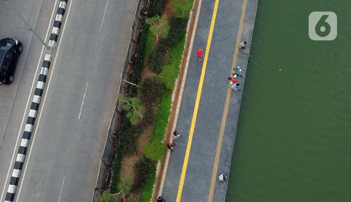 Foto udara memperlihatkan aktivitas warga di pedestrian Danau Sunter, Jakarta, Sabtu (27/6/2020). Beragam aktivitas dilakukan warga sambil menikmati waktu sore di area Danau Sunter, Jakarta. (Liputan6.com/Helmi Fithriansyah)