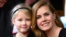 Amy Adams bersama anaknya berpose dengan plakat penghargaan dari Hollywood Walk of Fame di Los Angeles, AS, Kamis (12/1). Adams menerima plakat penghormatan atas perannya di film fiksi ilmiah Paramount Pictures Arrival. (AP Photo/ Rich Fury)