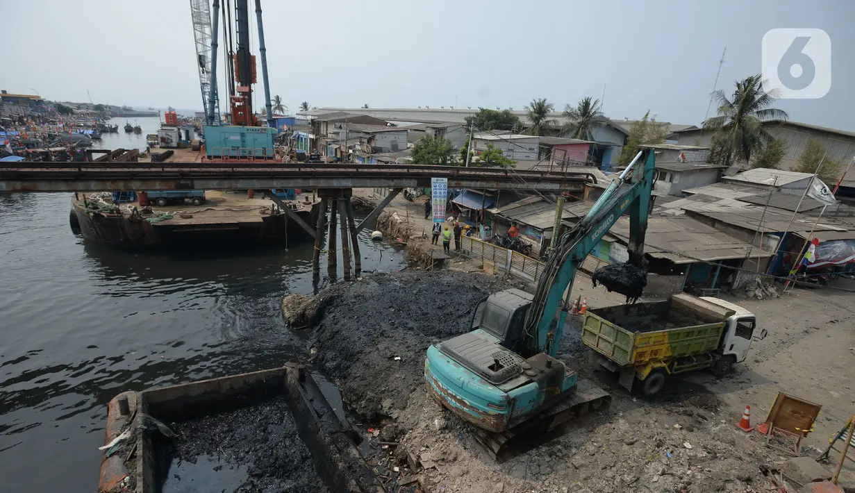 Alat berat mengangkat material endapan lumpur di Kampung Nelayan Cilincing, Jakarta Utara, Kamis (2/9/2021). Pengerukan dilakukan untuk mengurangi pendangkalan di muara teluk Jakarta serta penataan sandaran kapal-kapal tradisional. (merdeka.com/Imam Buhori)