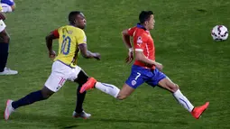 Penyerang Chile, Alexis Sanchez (kanan) berusaha mengejar bola dari kejaran bek Ekuador Walter Ayovi pada pertandingan pembukaan Copa America 2015 di National Stadium, Santiago, Chile, (11/6/2015). Chile menang 2-0 atas Ekuador. (REUTERS/Ueslei Marcelino)