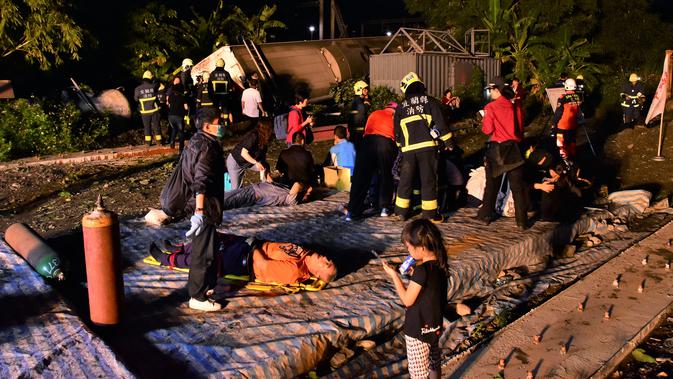 Petugas penyelamat menyelamatkan korban tergelincirnya kereta Puyuma Express di Yilan, Taiwan, Minggu (21/10). Sejauh ini belum diketahui pasti apa yang menyebabkan kereta itu tergelincir. (AP Photo)