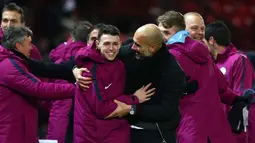 Pep Guardiola (tengah) melakukan selebrasi dengan pemainnya usai pertandingan melawan Manchester United di Liga Inggris di Old Trafford Stadium, Inggris, (10/12). Usai mengalahkan MU, City kokoh di puncak klasemen dengan poin 46. (AP Photo/Dave Thompson)