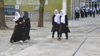 Anak perempuan tiba di sekolah mereka di Kabul (23/3/2022). Penutupan sekolah memicu kebingungan dan patah hati atas peristiwa tersebut. pembalikan kebijakan oleh kelompok Taliban. (AFP/Ahmad Sahel Arman)