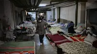 Anak-anak yang dirawat di rumah sakit pediatri ditempatkan tempat tidur mereka di ruang bawah tanah rumah sakit yang digunakan sebagai tempat perlindungan bom di Kiev, Senin (28/2/2022). Tentara Rusia mengatakan, warga sipil Ukraina dapat meninggalkan ibu kota Kiev dengan bebas. (Aris Messinis / AFP