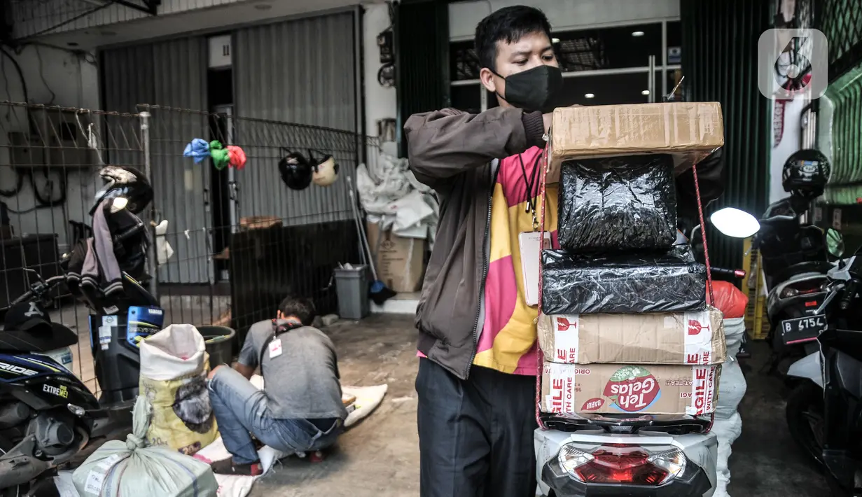Pekerja menyelesaikan pengemasan paket di sepeda motor sebelum diantarkan ke konsumen di perusahaan jasa ekspedisi online, Jakarta, Kamis (23/9/2021). Kenaikan di sepanjang semester I/2020 secara tahunan dengan total nilai transaksi mencapai Rp186,75 triliun. (merdeka.com/Iqbal S. Nugroho)