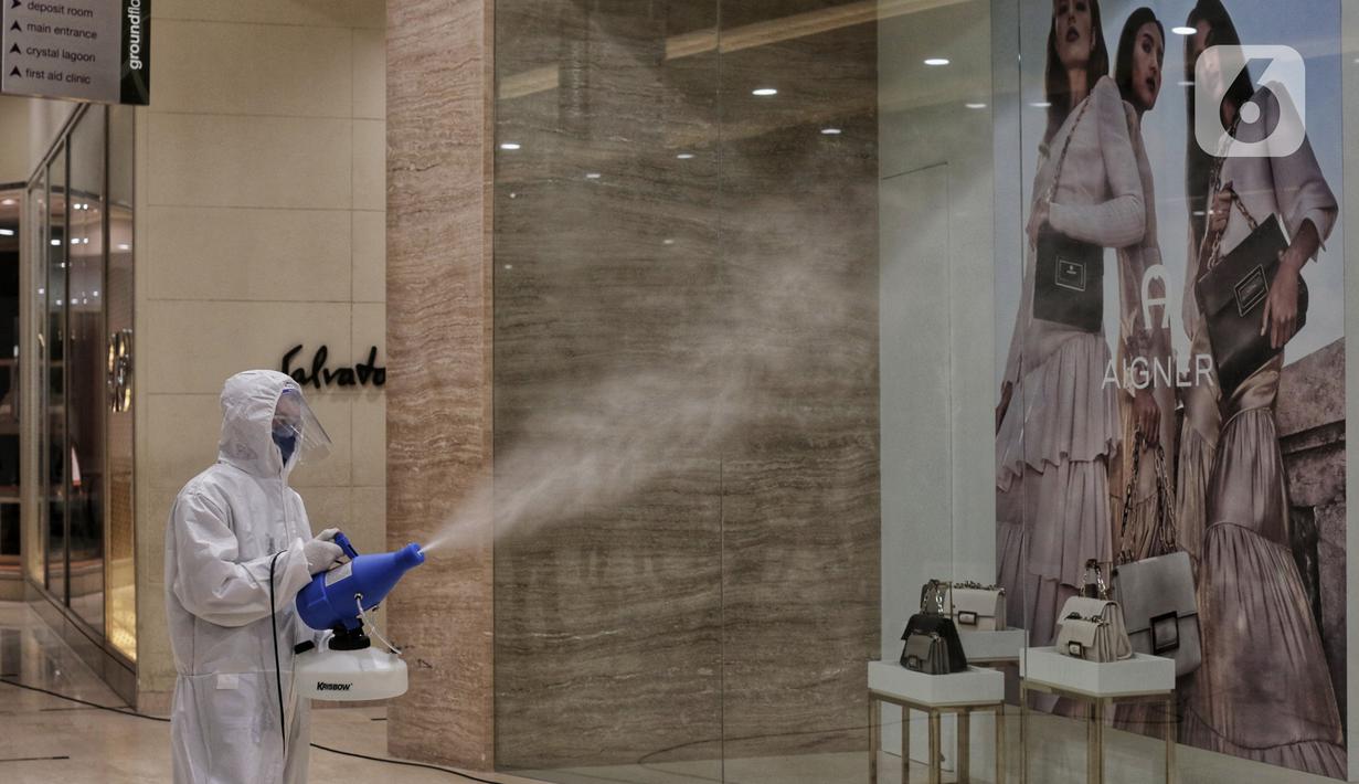 Petugas menyemprotkan cairan disinfektan di Senayan City, Jakarta, Selasa (9/6/2020). Senayan City siap menyambut pengunjung kembali pada 15 Juni 2020 dengan menerapkan berbagai protokol pencegahan COVID-19 seperti pengecekan suhu tubuh sensor tanpa sentuh untuk lift. (Liputan6.com/Johan Tallo)