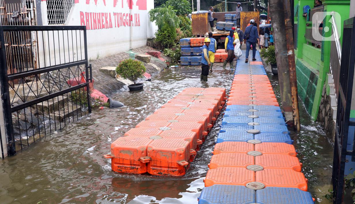 Petugas membuat jembatan apung saat banjir melanda Perumahan Periuk Damai, Tangerang, Banten, Selasa (23/2/2021). Adanya jembatan apung mempermudah warga saat melintasi banjir setinggi 2,5 meter di tempat tersebut. (Liputan6.com/Angga Yuniar)