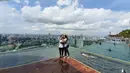 Perempuan yang sekarang berprofesi sebagai DJ tersebut tampak mesra dengan kekasihnya. Masih menggunakan baju kaus putih, celana berwarna gelap, dan dilengkapi sneakers dan tas kecil, ia berpose dengan pemandangan langit Singapura. (Liputan6.com/IG/@itssheilamj)
