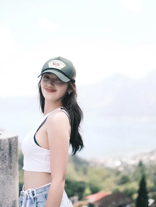 Penampilan lain juga dibagikan Ranty ketika berada di Bali. Kali ini dengan penampilan kasual crop tank top putih dan celana jeans. Bra hitam yang sedikit terlihat di balik baju juga menjadi detail menarik yang mempertegas gaya Ranty yang berani namun tetap elegan. (Liputan6.com/IG/@rantymaria)