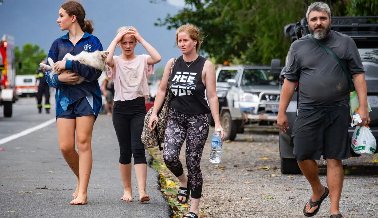 Orang-orang tiba di Cairns pada 18 Desember 2023, setelah dievakuasi dari rumah mereka di pinggiran kota bagian utara. (Brian CASSEY/AFP)
