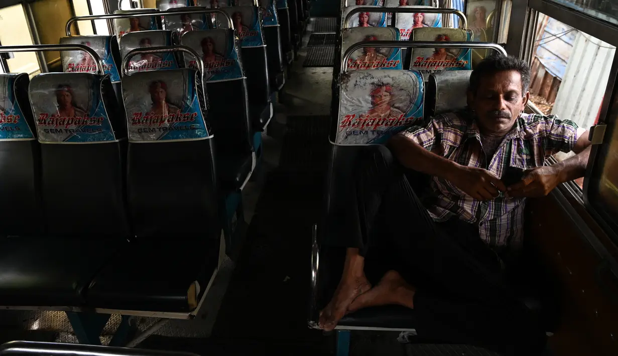 Pengemudi duduk di dalam bus sambil menunggu untuk membeli solar di pompa bensin di Kolombo, Rabu (2/3/2022). Sri Lanka sehari sebelumnya mengumumkan pemadaman listrik setiap hari selama tujuh setengah jam, karena krisis valuta asing membuatnya tidak dapat mengimpor minyak. (Ishara S. KODIKARA/AFP)