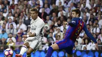 Salah satu upaya bek Barcelona, Gerard Pique untuk menghentikan pergerakan penyerang Real Madrid, Cristiano Ronaldo. (GERARD JULIEN / AFP)