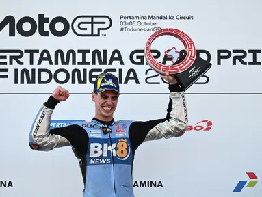 Pembalap MotoGP Spanyol tim BK8 Gresini Racing, Fermin Aldeguer, merayakan kemenangan di podium usai menjuarai balapan MotoGP Indonesia 2025 di Sirkuit Mandalika, Lombok, pada Minggu (5/10/2025). (AFP/Sonny Tumbelaka).