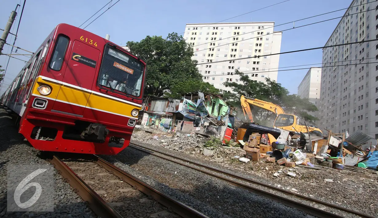 Alat berat merobohkan bangunan di kawasam Rawajati, Jakarta, Kamis (1/9). Penertiban puluhan bangunan liar di kawasan tersebut menyebabkan warga terpaksa menyelamatkan barang berharga mereka ke tepi rel kereta api. (Liputan6.com/Immanuel Antonius)