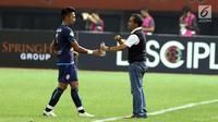Pelatih Arema FC, Aji Santoso (kanan) memberi arahan pada Bagas Adi Nugroho saat laga lanjutan Liga 1 Indonesia melawan Persija di Stadion Patriot Candrabhaga, Bekasi, Jumat (2/6). Persija unggul 2-0 atas Arema FC. (Liputan6.com/Helmi Fithriansyah)